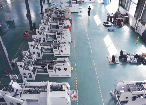Factory floor with several paper bag machines of different sizes, labeled "comparison view